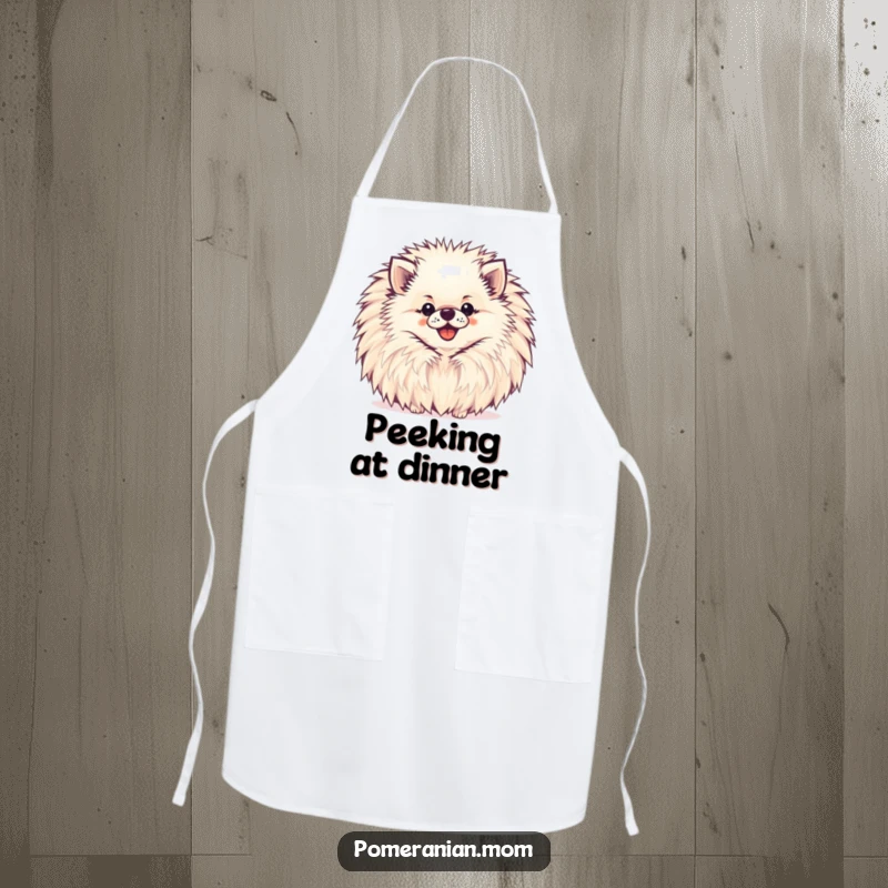 Funny Pomeranian Apron showing a happy Pomeranian peeking from behind a large, cheerful pompom while cooking.