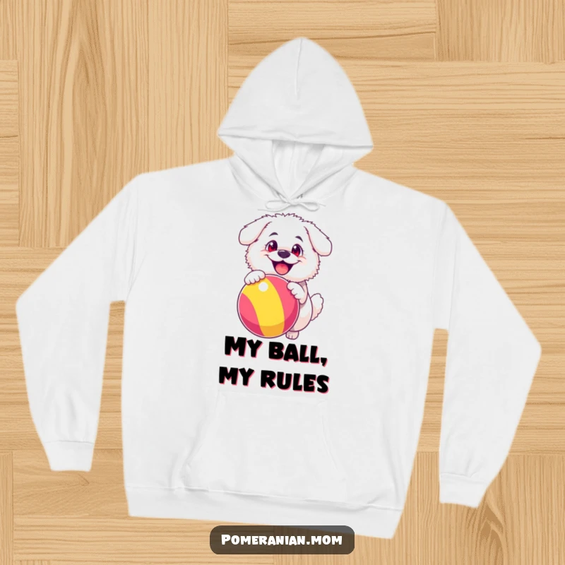 Funny hoodie illustration of a fluffy white dog with comically happy eyes, bouncing a large, vibrant ball, capturing maximum canine joy.