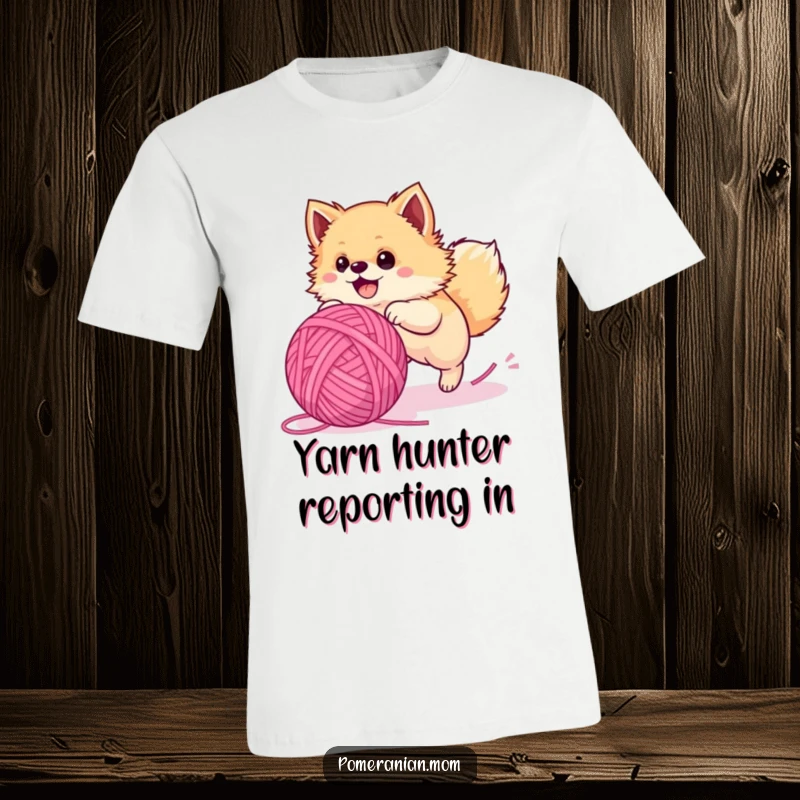 Funny Pomeranian t-shirt, a delighted fluffy dog in hot pursuit of a comically large yarn ball, bursting with energy.
